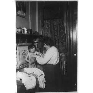 All over day in the tenements,woman bathing small crying child in sink 