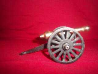 DESCRIPTION  VINTAGE CASET IRON AND BRASS CANNON TOY. THE CANNON HAS 